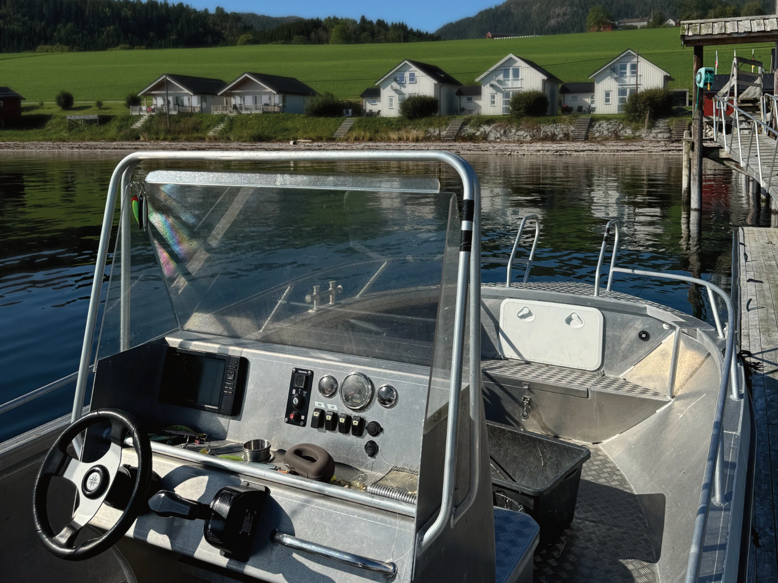Utleiebåt ved brygga med Hindrum Fjordsenter i bakgrunnen